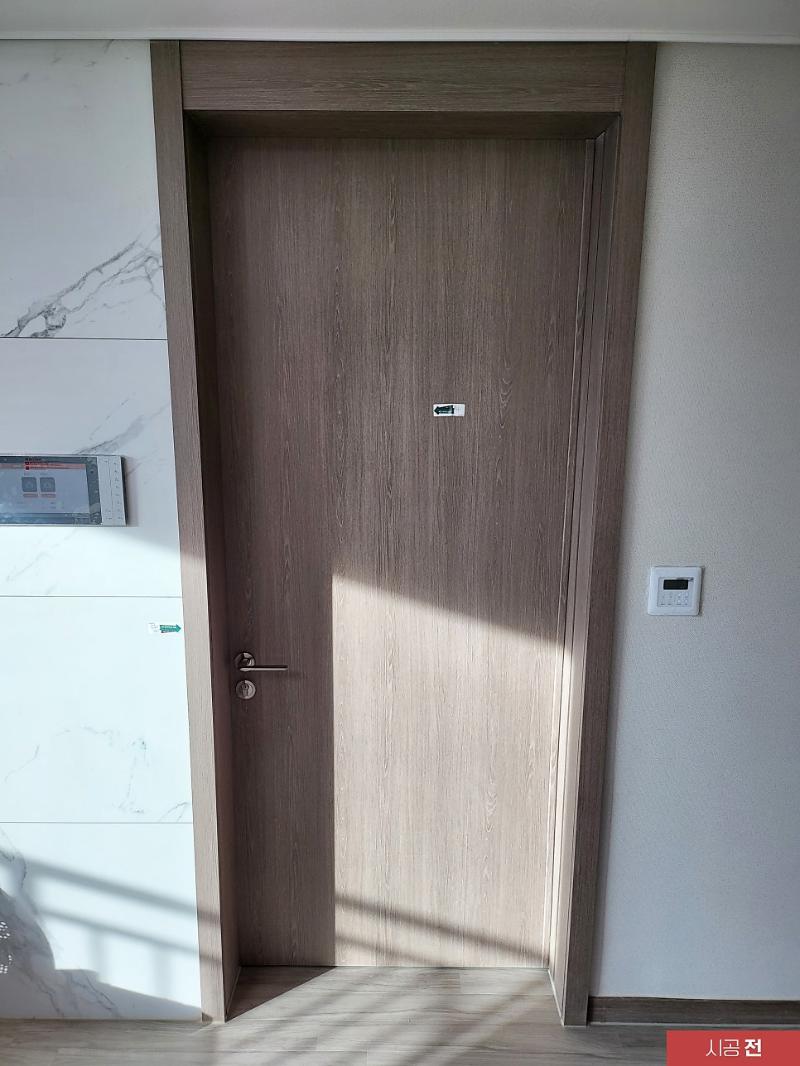 짙은 갈색 목재 패턴의 시공 전 도어 모습