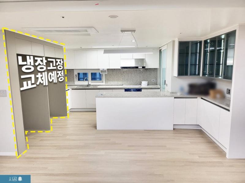 화이트 수납장과 아일랜드가 배치된 주방 전경
