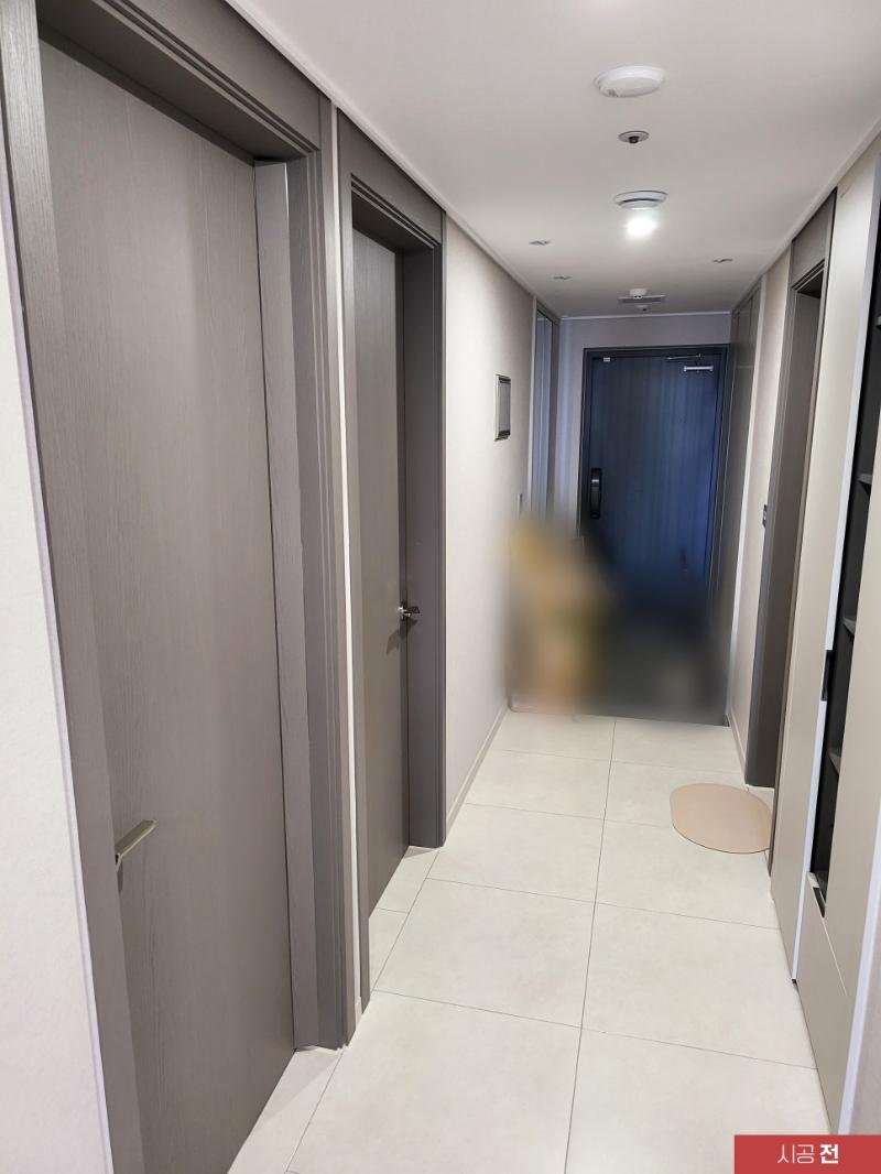 어두운 색의 문들이 배치된 시공 전 복도 전경