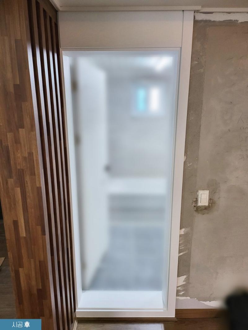 화이트로 랩핑된 도어 프레임과 유리 패널의 실리콘 마감