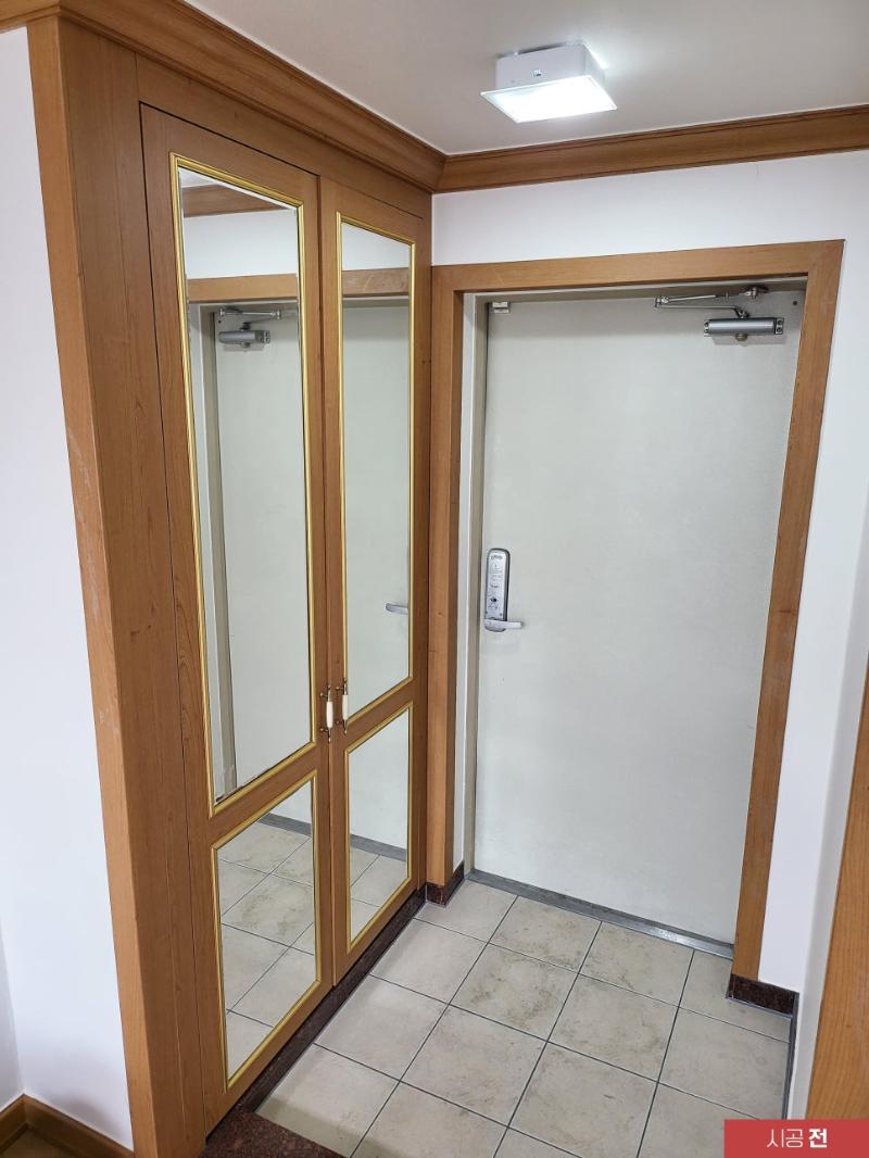 나무 테두리 도어가 보이는 시공 전 현관
