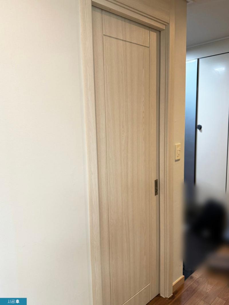 시트지 시공 후 힌지가 보이는 여닫이 도어