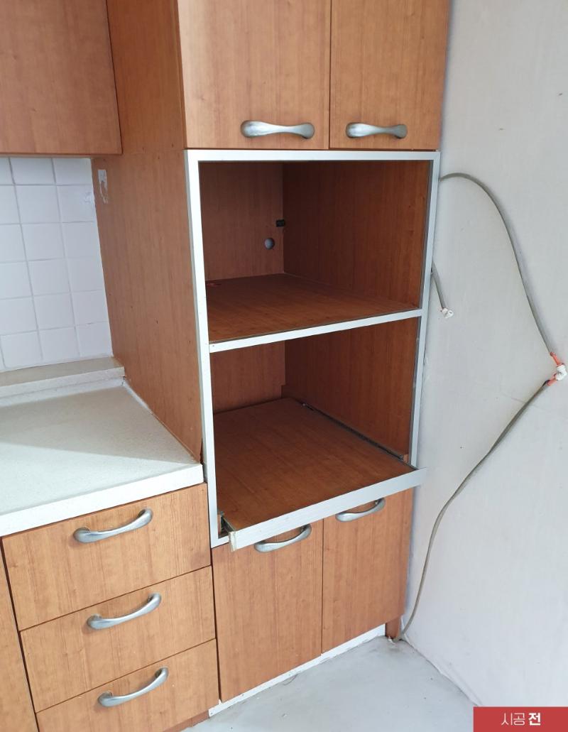 전선이 노출된 상태의 목재 수납장과 베이지색 바닥