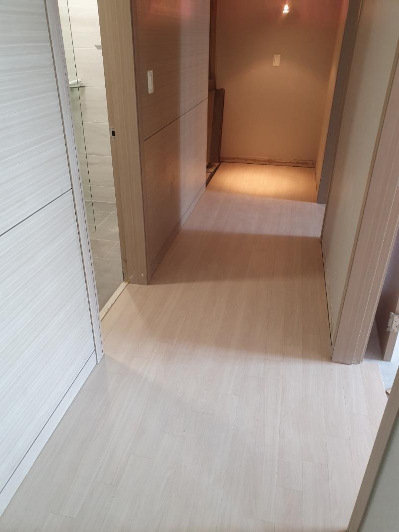 베이지색 벽지와 밝은 톤의 마루가 완성된 복도