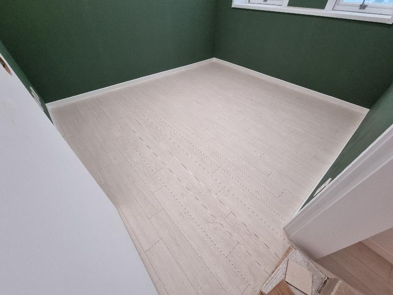 녹색·흰색 벽면과 창문, 목재 마루가 깔린 모습