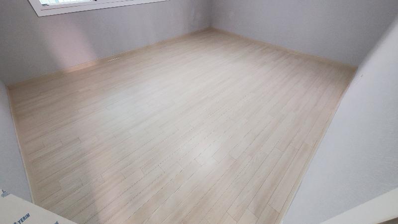 밝은 색상의 마루로 마감된 빈 공간의 모습
