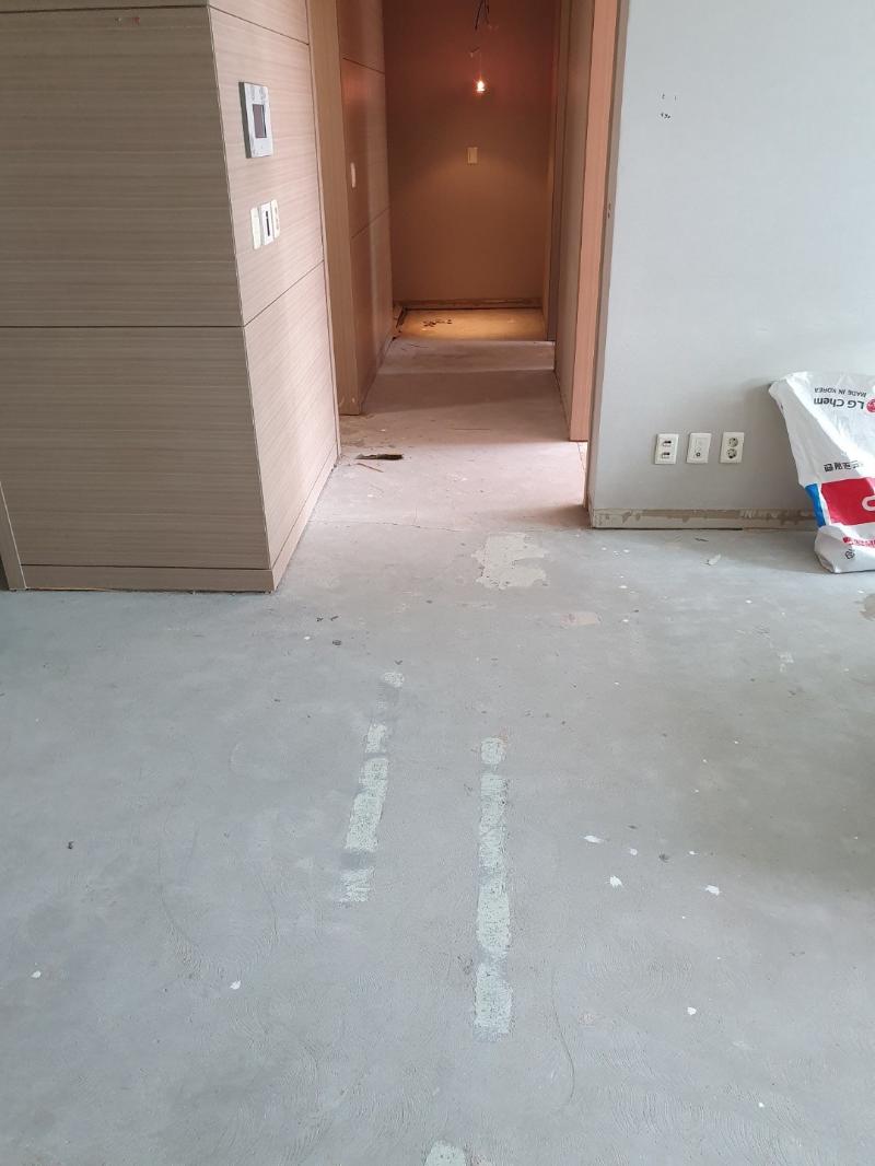 회색 콘크리트 바닥이 노출된 복도 시공 전 모습