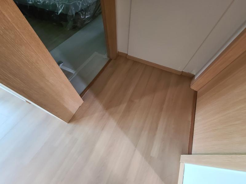 목재 도어들이 배치된 복도의 마루 마감 모습