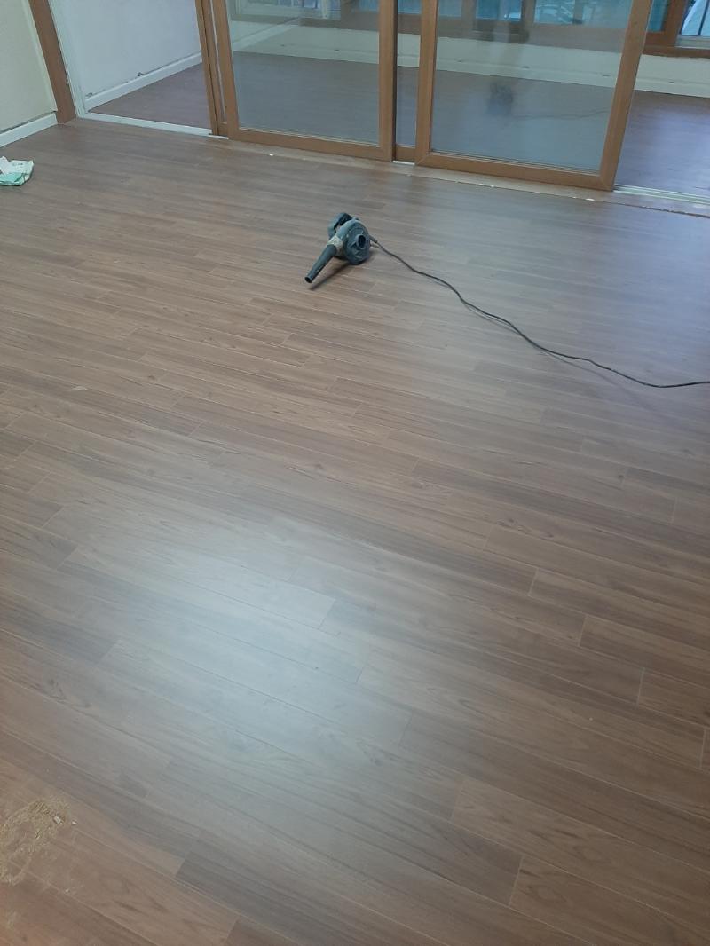 공기 흡입기와 전선이 놓인 마루 시공 현장
