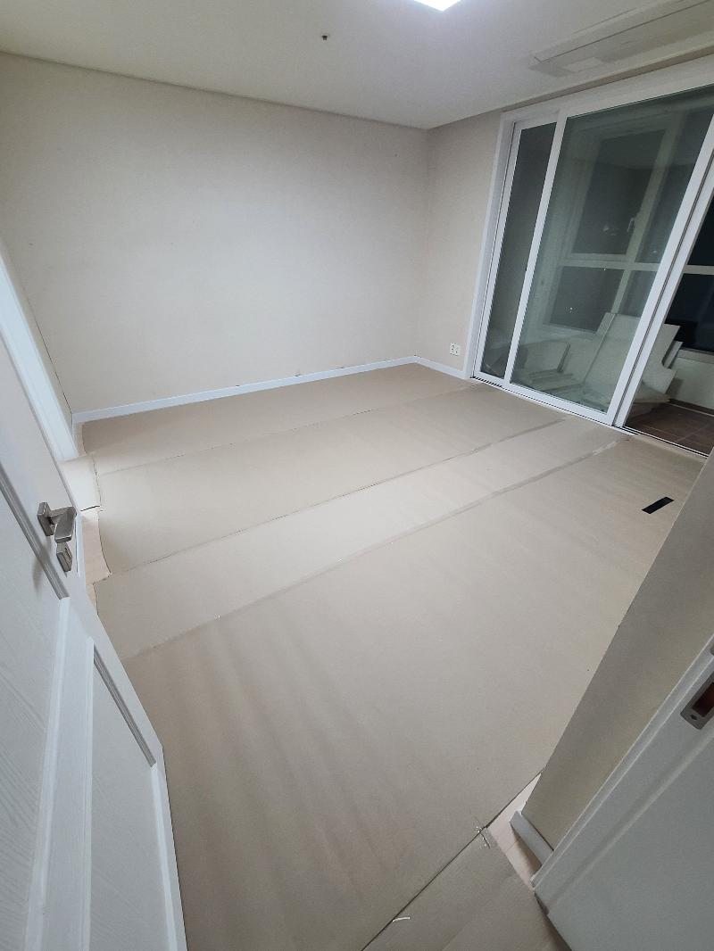 흰색 문과 슬라이딩 도어가 있는 베이지색 바닥의 방