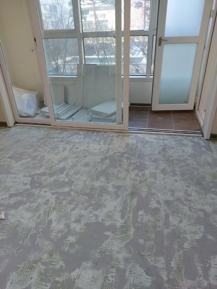 흙과 먼지가 덮인 바닥과 슬라이딩 도어가 보이는 공간