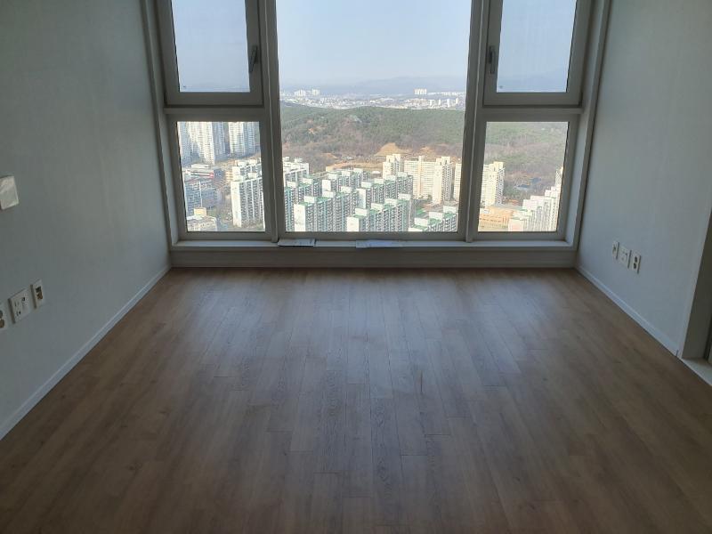 도시 풍경이 보이는 창가와 목재 바닥의 조화
