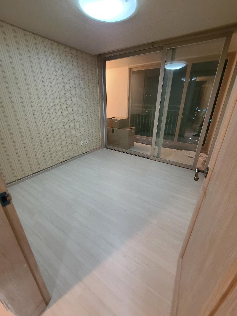 창가 빛이 들어오는 밝은 바닥재와 원형 조명이 보이는 실내