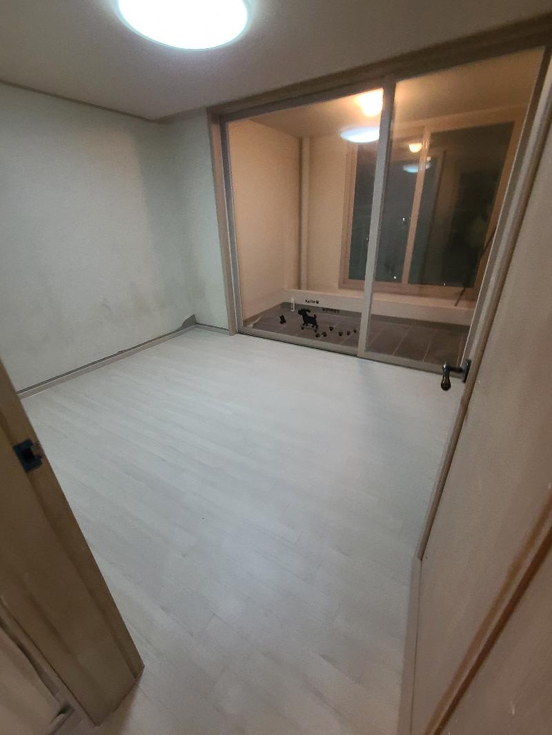 슬라이딩 도어와 흰 벽이 맞닿은 밝은 색 바닥재