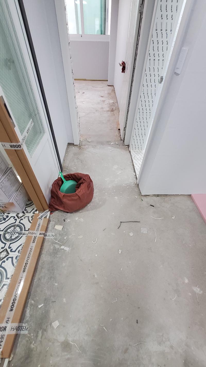 콘크리트 바닥과 도배가 진행 중인 복도 모습