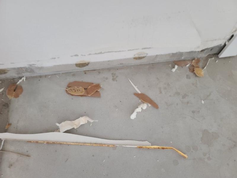 벽면 상단 마감재와 바닥의 파편들이 보이는 모습