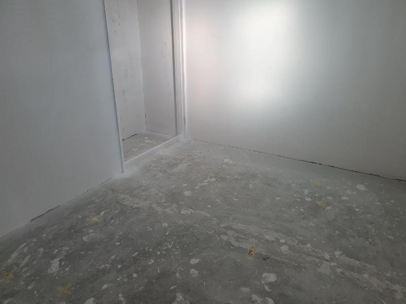 흰색 페인트가 칠해진 바닥과 퍼티 작업 중인 벽면
