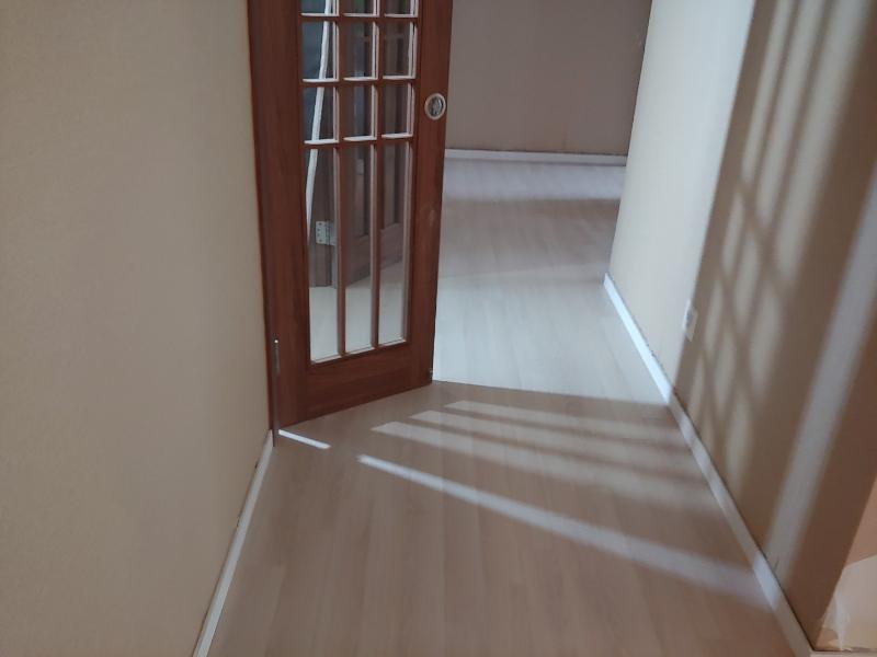 베이지색 벽지와 유리 패널 도어가 있는 복도