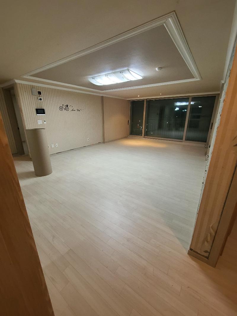 큰 창문과 라인 조명이 있는 넓은 공간의 목재 바닥재