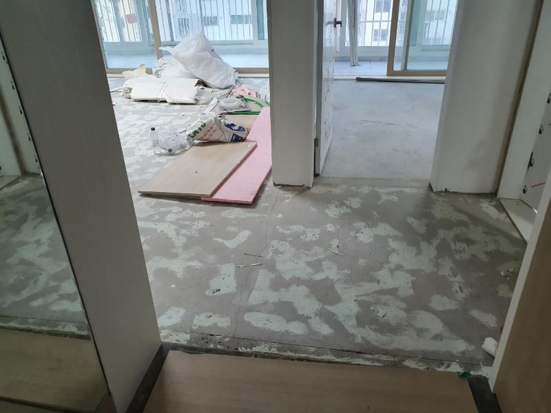 건축 자재들이 흩어져 있는 실내 바닥 상태