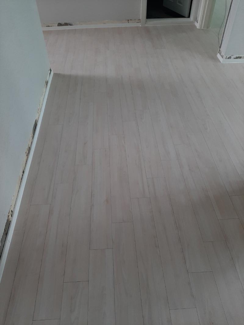 흰색 벽과 바닥재가 만나는 복도 구간
