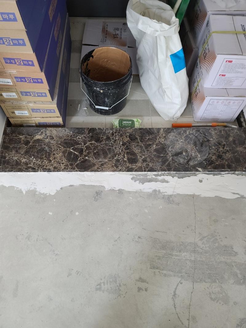 바닥 면처리를 위해 흰색 마감재를 도포 중인 모습