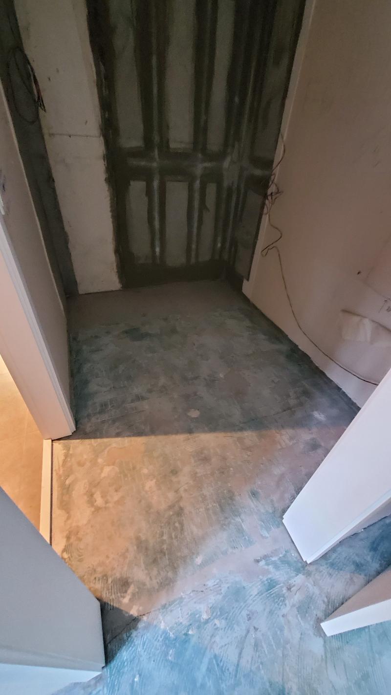 벽면 페인트 작업과 바닥 철거 상태의 복도