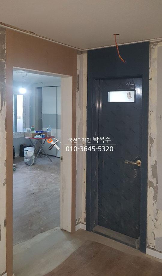 검은색 도어가 설치된 현관 입구의 공사 현장
