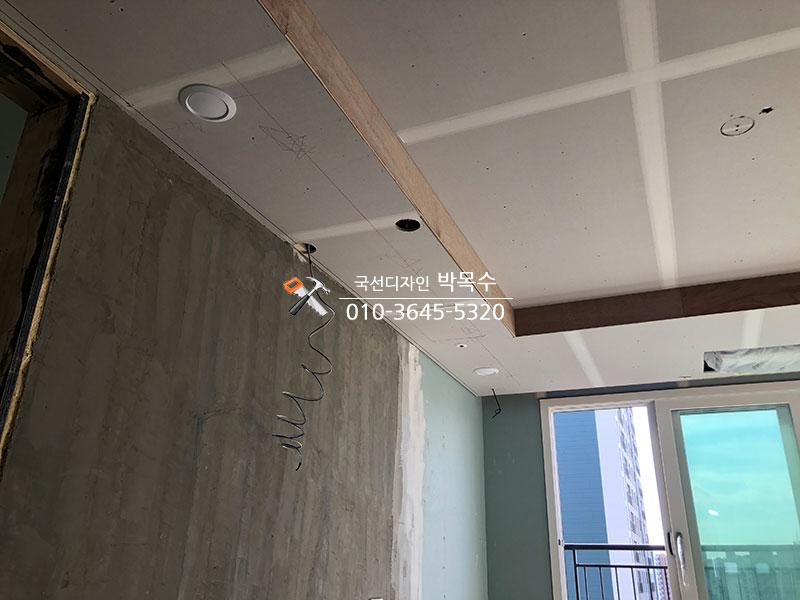 목재 보와 백색 패널이 설치된 천장과 콘크리트 벽면