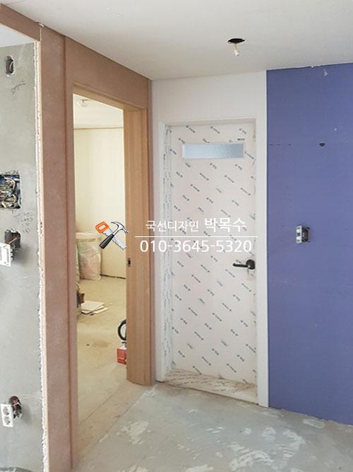 문틀 설치와 전기 배선 작업이 진행 중인 복도