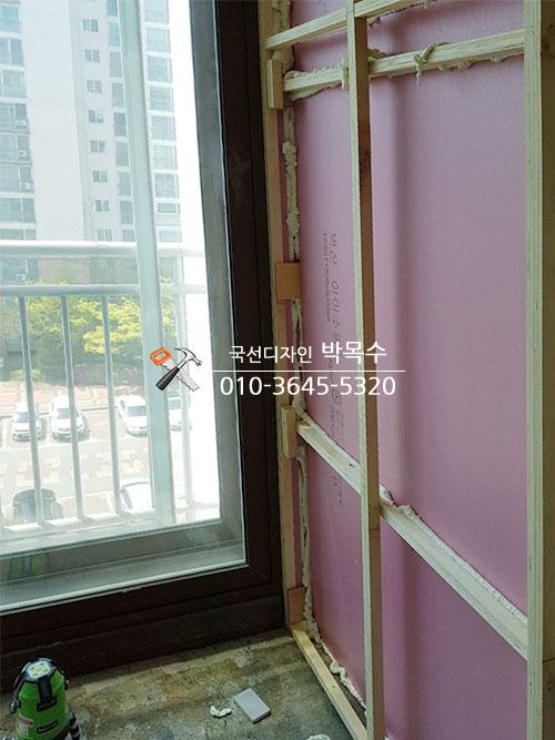 창호 인접 벽면의 목재 프레임과 핑크색 보온재 설치
