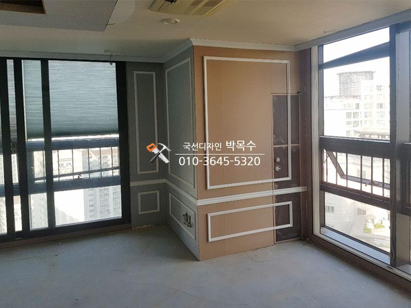창호 주변 베이지와 회색 패널의 기초 마감