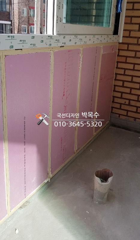 벽돌 벽면에 부착된 분홍색 보온재