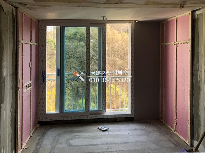 분홍색 단열 보드가 부착된 창가 벽면과 콘크리트 바닥