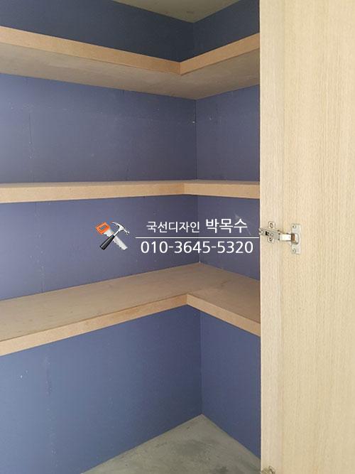 나무 문과 ㄱ자 선반이 설치된 매입장 내부