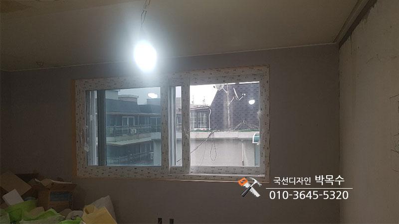 테이프가 부착된 벽면과 설치 중인 창호의 모습
