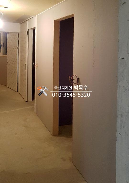 흰색으로 마감된 복도 벽면과 콘크리트 바닥
