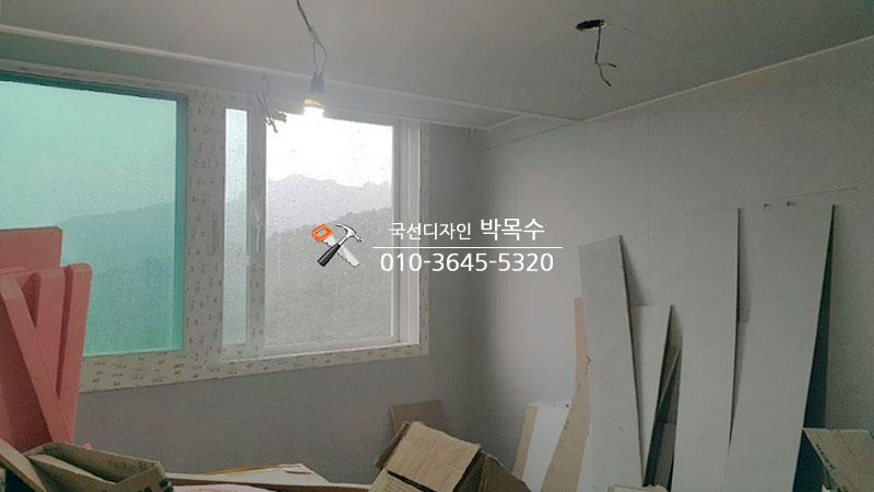 판재와 박스가 놓인 공사 중인 실내 전경