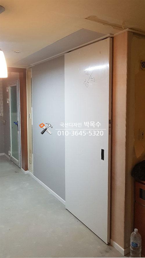 흰색 슬라이딩 문과 유리문이 설치된 복도