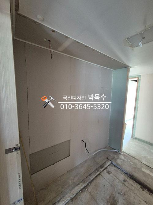 벽면 보드 설치와 전선 노출이 보이는 실내 공간