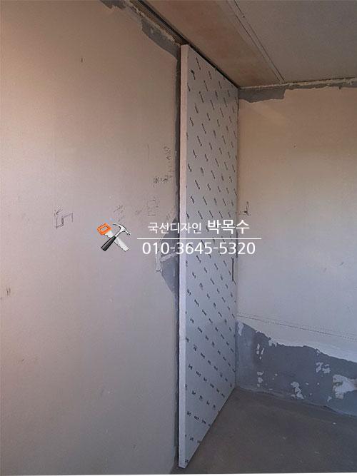 부분 도배된 벽면과 설치된 금속판