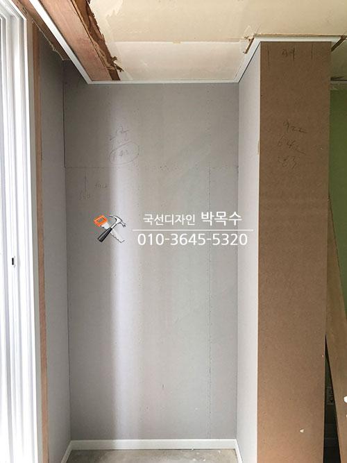 천장 구조물이 노출된 회색 벽면의 복도 공간