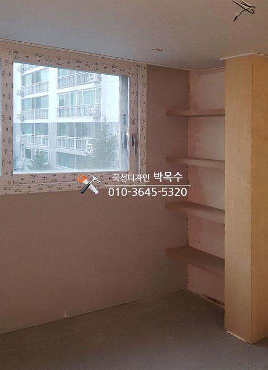 벽면에 고정된 무지주 선반 구조물과 콘크리트 바닥