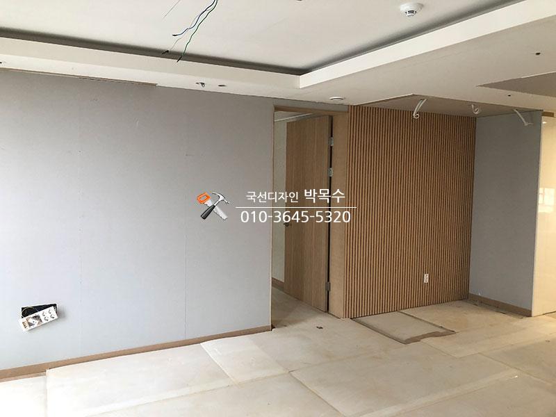 나무 패널로 분리벽을 세운 복도 공간