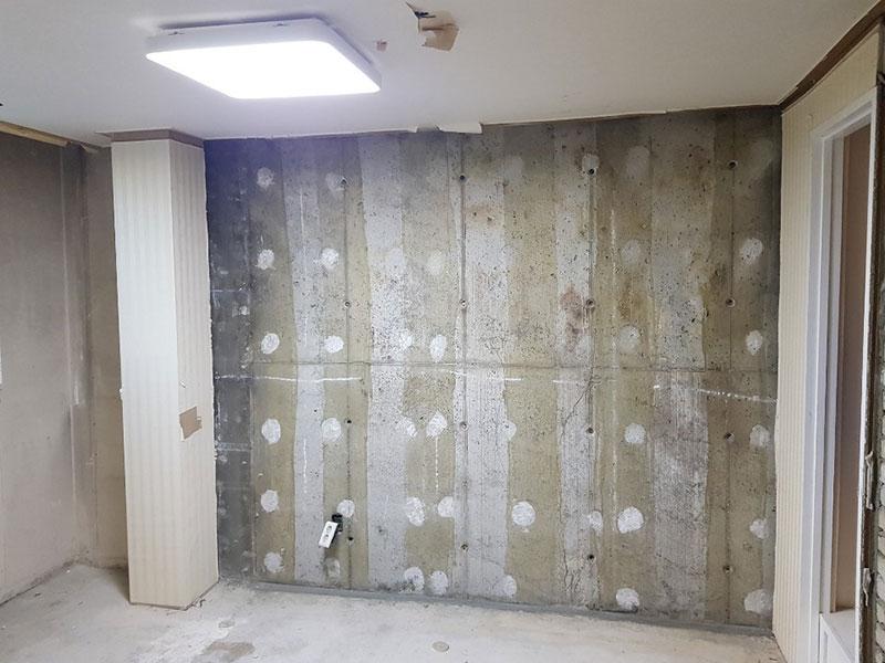 콘크리트 벽면과 마감된 컬럼이 보이는 공간