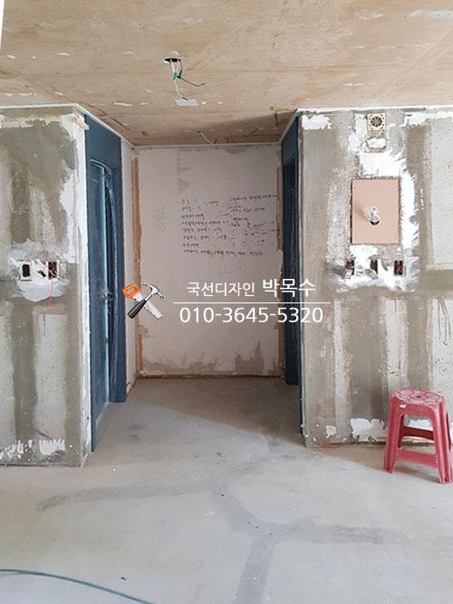 천장 목재 보드 시공과 벽면 정리가 진행 중인 복도