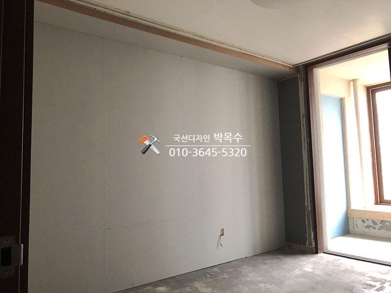 콘크리트 바닥과 흰 벽면이 보이는 텅 빈 방의 모습