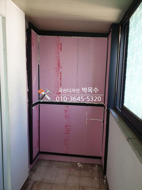 벽면에 부착된 분홍색 보온재와 검은색 창호 프레임