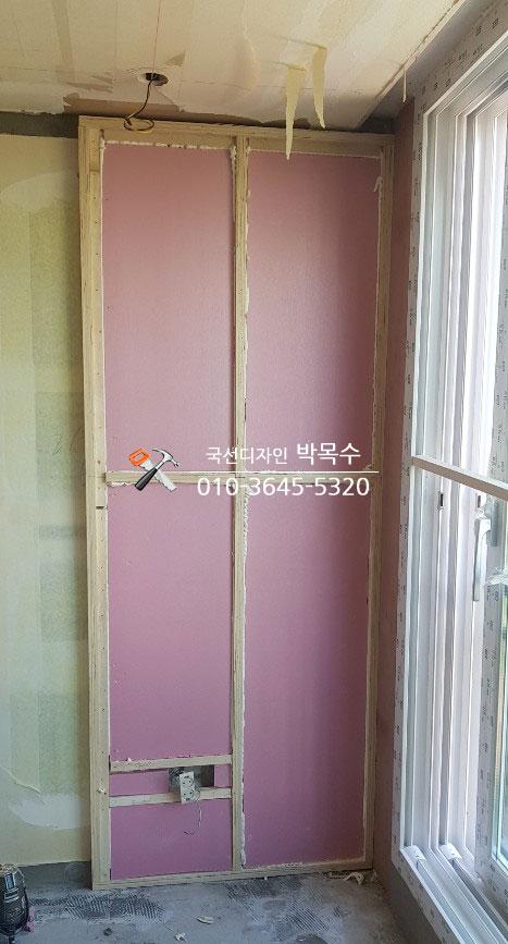 핑크색 보드와 목재 프레임이 설치된 벽면