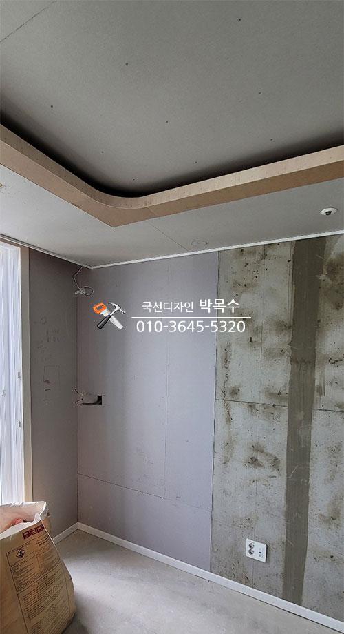 마감 전의 벽면과 창가에 걸린 흰색 커튼